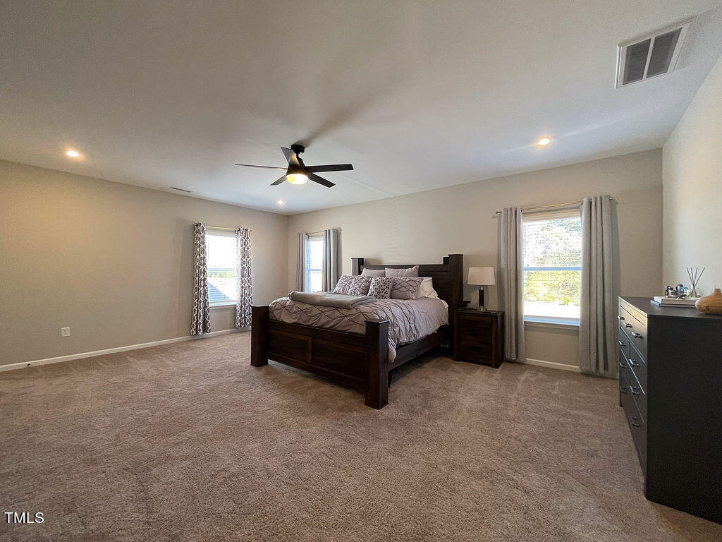 3604 Cross Timber Lane Raleigh, NC 27603 - Photo 9 of 15 a spacious bedroom with a bed and a chandelier