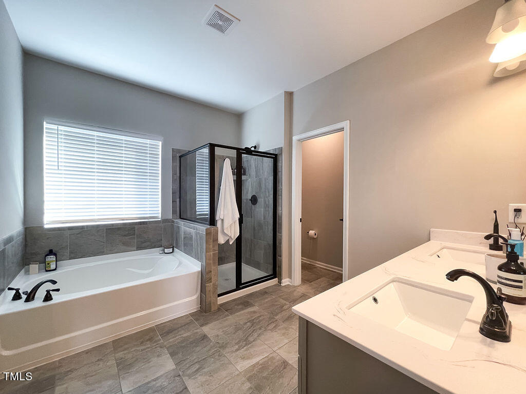 3604 Cross Timber Lane Raleigh, NC 27603 - Photo 10 of 15 a bathroom with a tub sink and mirror
