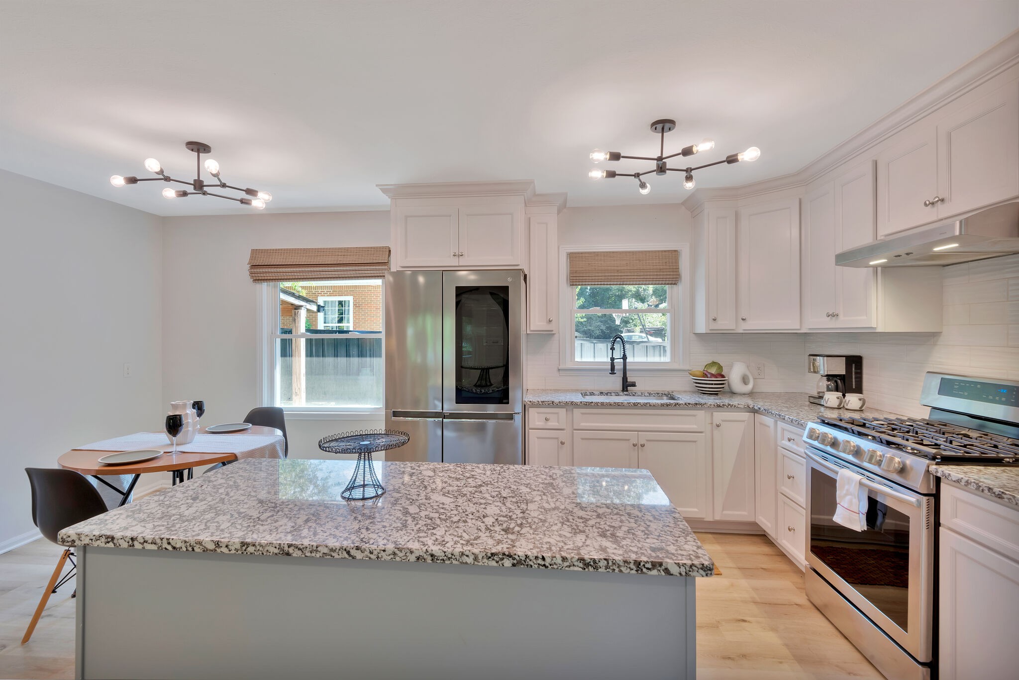 212 Pump Hill Road Dickson, TN 37055 - Photo 9 of 27 a kitchen with stainless steel appliances granite countertop a sink dishwasher a stove a dining table and chairs with wooden floor