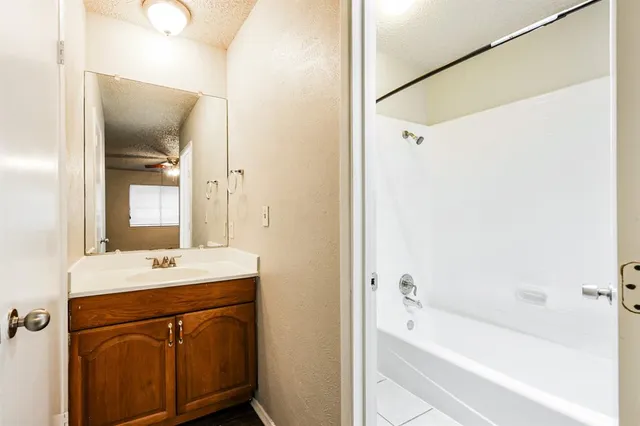 a bathroom with a bathtub sink vanity and mirror