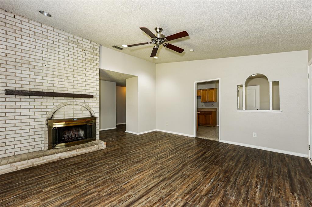 218 Long Shadow Lane Mesquite, TX 75149 - Photo 3 of 15 a view of an empty room with wooden floor fireplace and a window