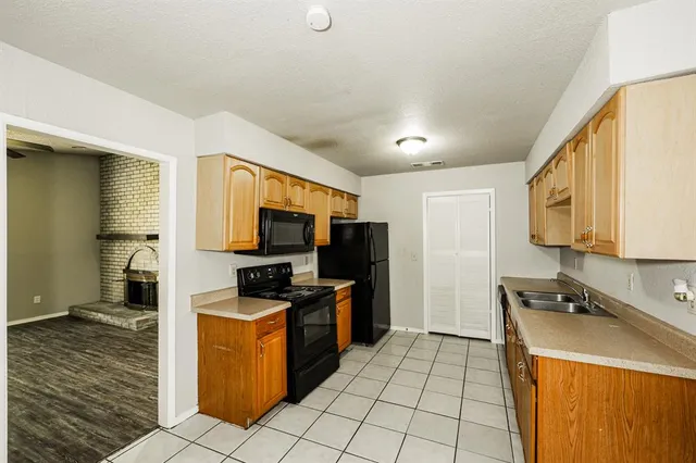 a kitchen with stainless steel appliances granite countertop a stove top oven a sink and a refrigerator