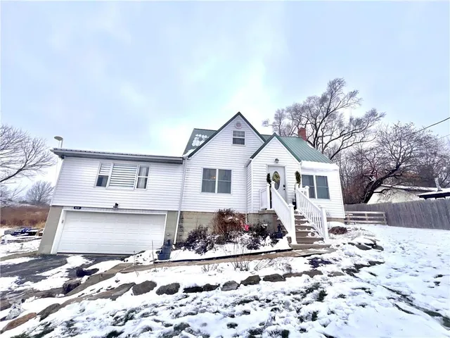 a front view of a house with a yard covered in snow