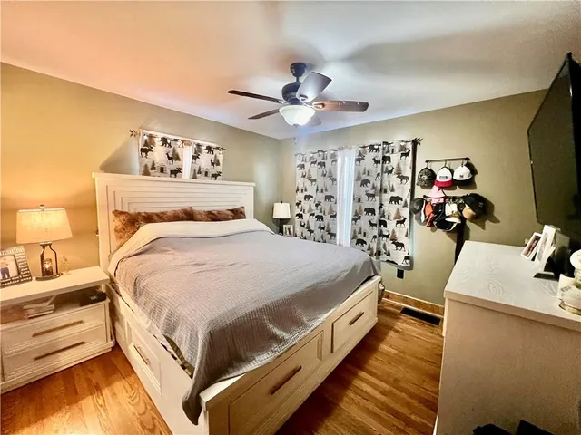a bedroom with a bed and a flat tv screen on dresser