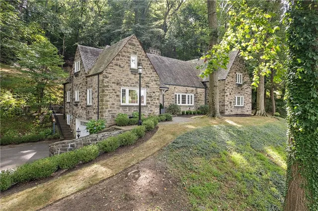 a view of a big house with large trees and plants