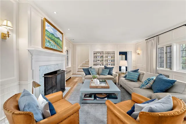 a living room with furniture fireplace and a large window