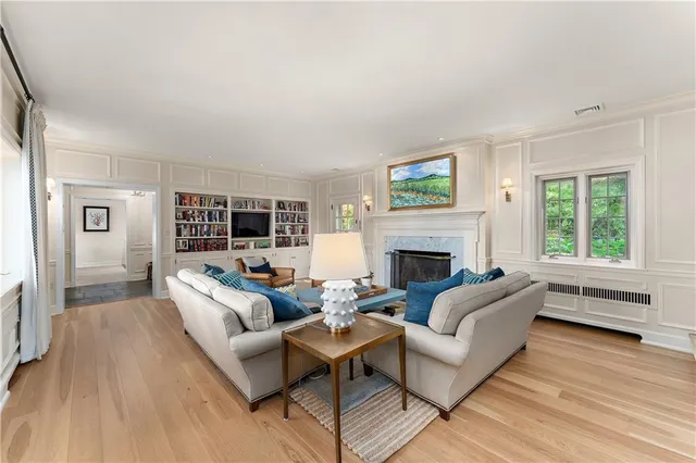 a living room with furniture large window and a fireplace