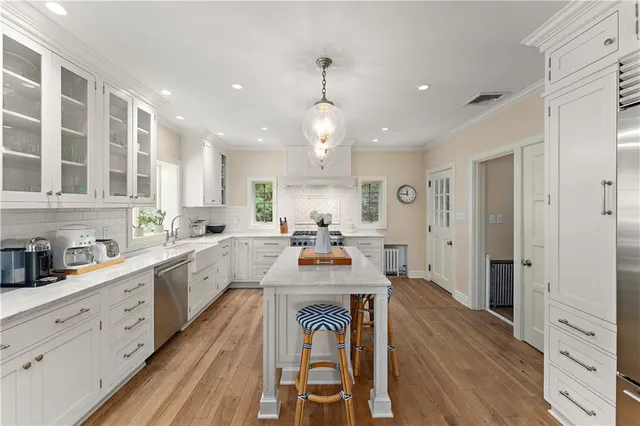 a large kitchen with sink cabinets and wooden floor