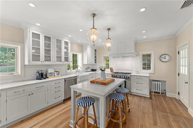 a kitchen with cabinets a sink dishwasher stove and wooden floor