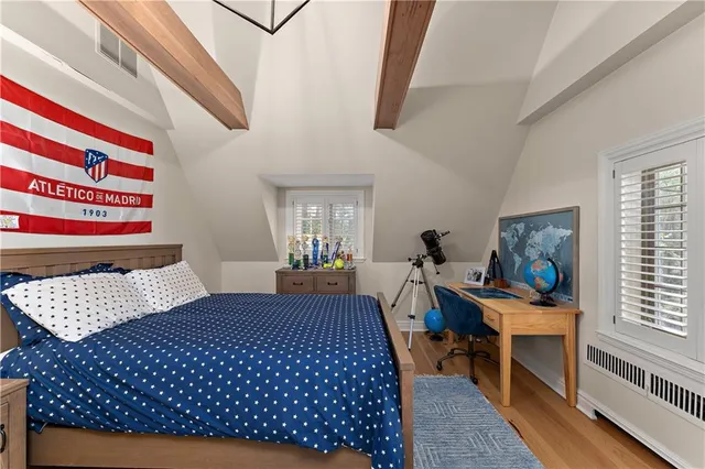 a bedroom with a bed and wooden floor