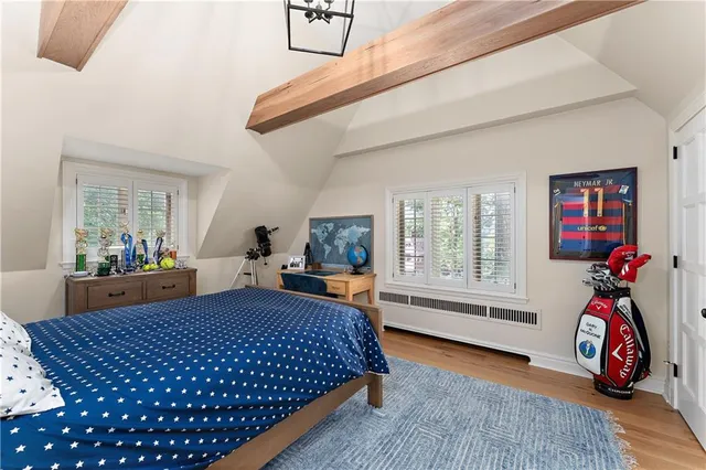 a bedroom with bed and wooden floor