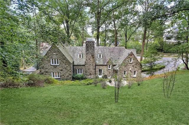 a view of a big house with big yard and large tree