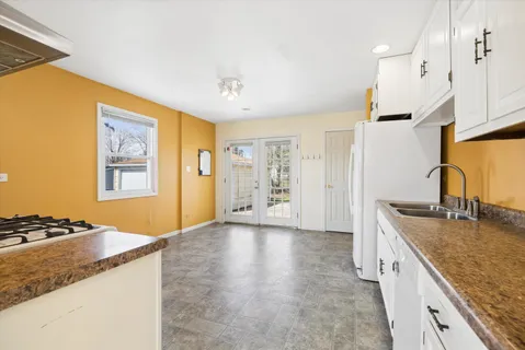 a kitchen with granite countertop a sink stove and refrigerator