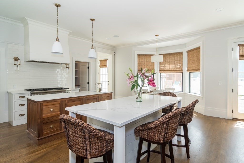 274 Manning Street Needham, MA 02492 - Photo 7 of 26 a kitchen with stainless steel appliances granite countertop a stove a refrigerator a kitchen island a dining table and chairs with wooden floor