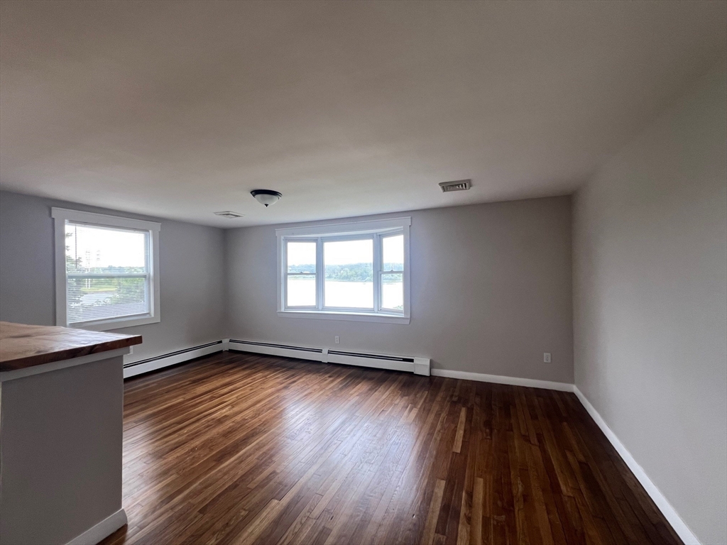 22 Eisenhower Road Swansea, MA 02777 - Photo 6 of 17 an empty room with wooden floor and windows