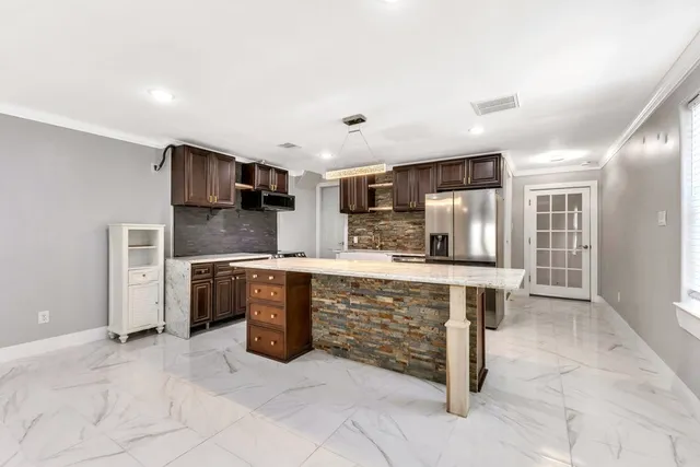a large kitchen with kitchen island a sink stainless steel appliances and cabinets