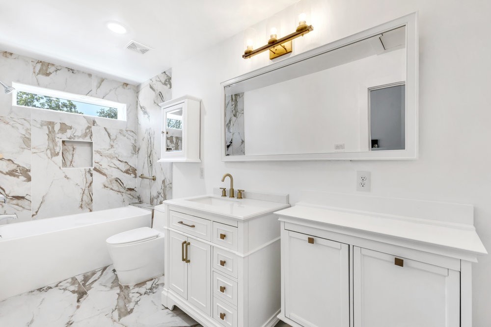 6325 Riverview Way, Unit ABCD Houston, TX 77057 - Photo 24 of 33 a bathroom with a sink a toilet a mirror and shower