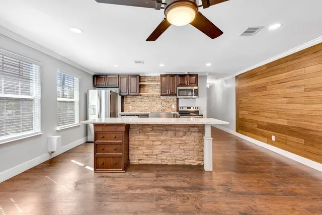 a view of kitchen with stainless steel appliances granite countertop a stove and a refrigerator