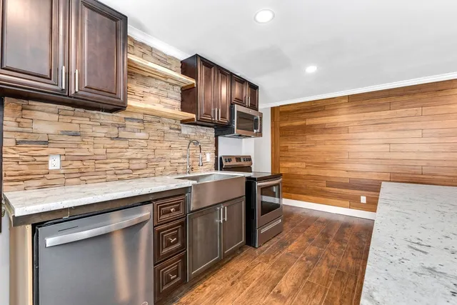 a kitchen with stainless steel appliances granite countertop a sink stove and oven