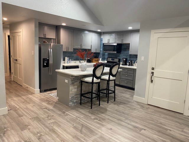 6325 Riverview Way, Unit ABCD Houston, TX 77057 - Photo 33 of 33 a kitchen with stainless steel appliances kitchen island granite countertop a refrigerator a stove a microwave oven a sink with island and chairs