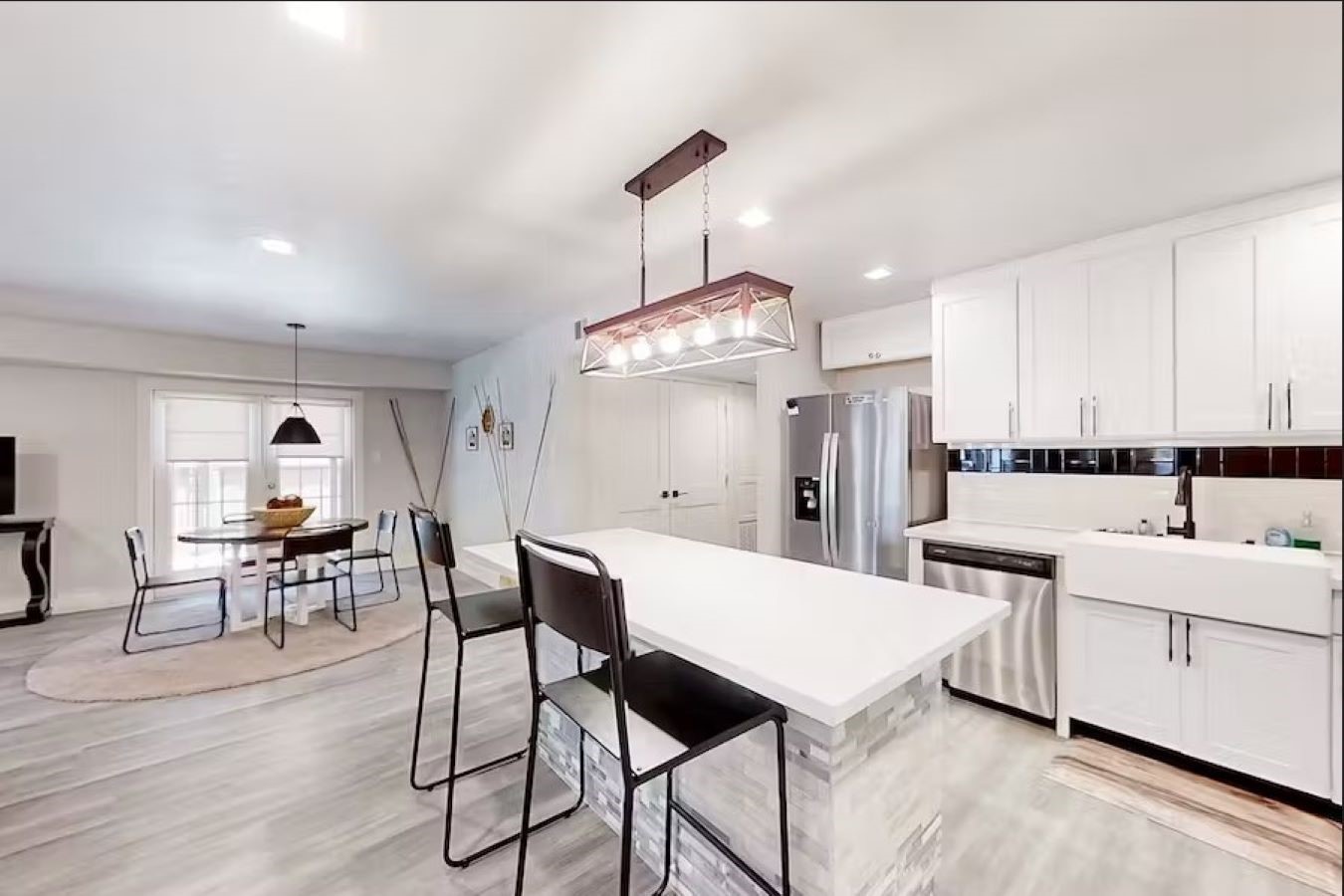 6325 Riverview Way, Unit ABCD Houston, TX 77057 - Photo 4 of 33 a kitchen with stainless steel appliances kitchen island granite countertop a refrigerator a stove a dining table and chairs with wooden floor