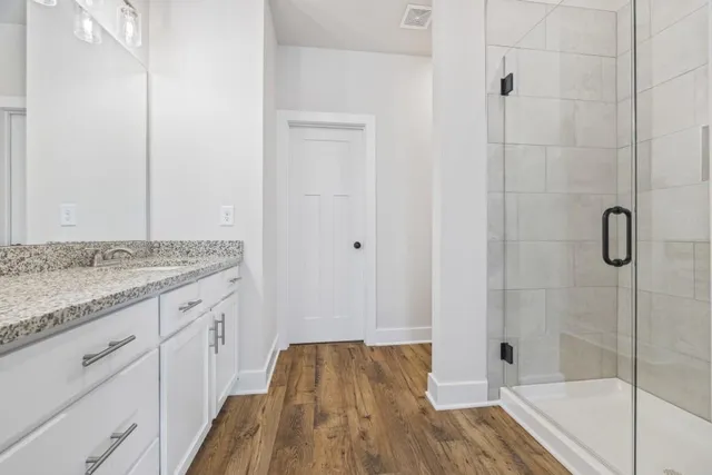 a bathroom with a granite countertop sink a mirror a vanity and a bathtub