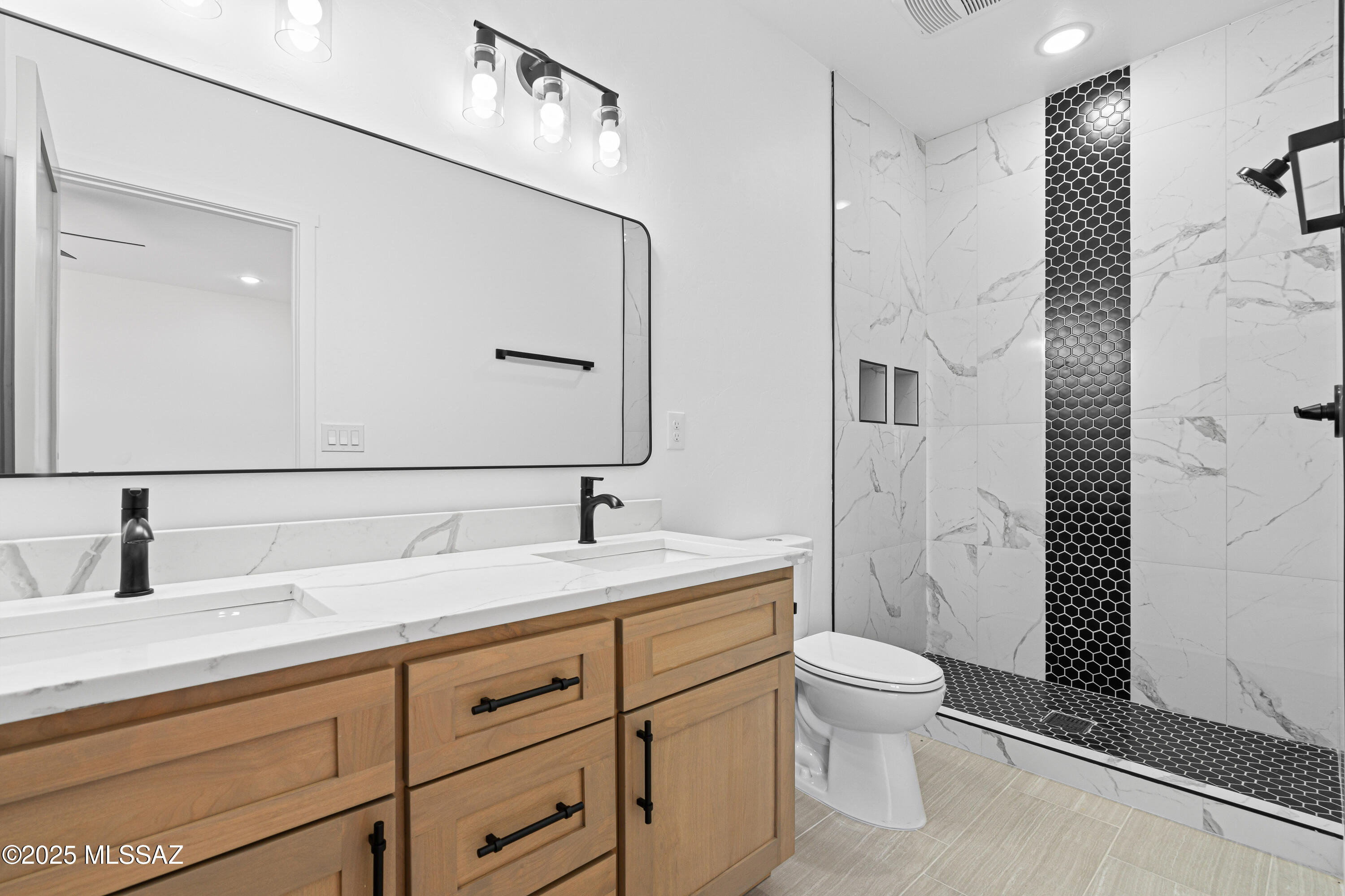 1560 Pinguinos Court Rio Rico, AZ 85648 - Photo 26 of 33 a bathroom with a granite countertop sink a toilet a mirror and shower