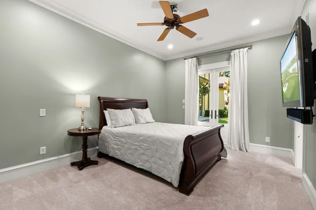 a bedroom with a bed and a flat tv screen on dresser