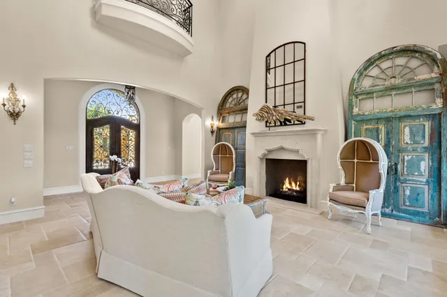 a living room with furniture a fireplace and potted plants with wooden floor
