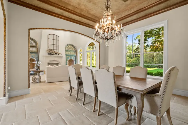 a view of a dining room with furniture a chandelier and window