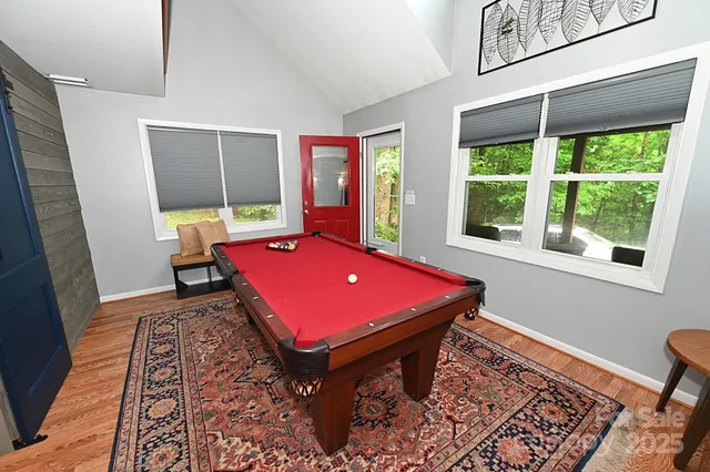 a room with pool table and windows