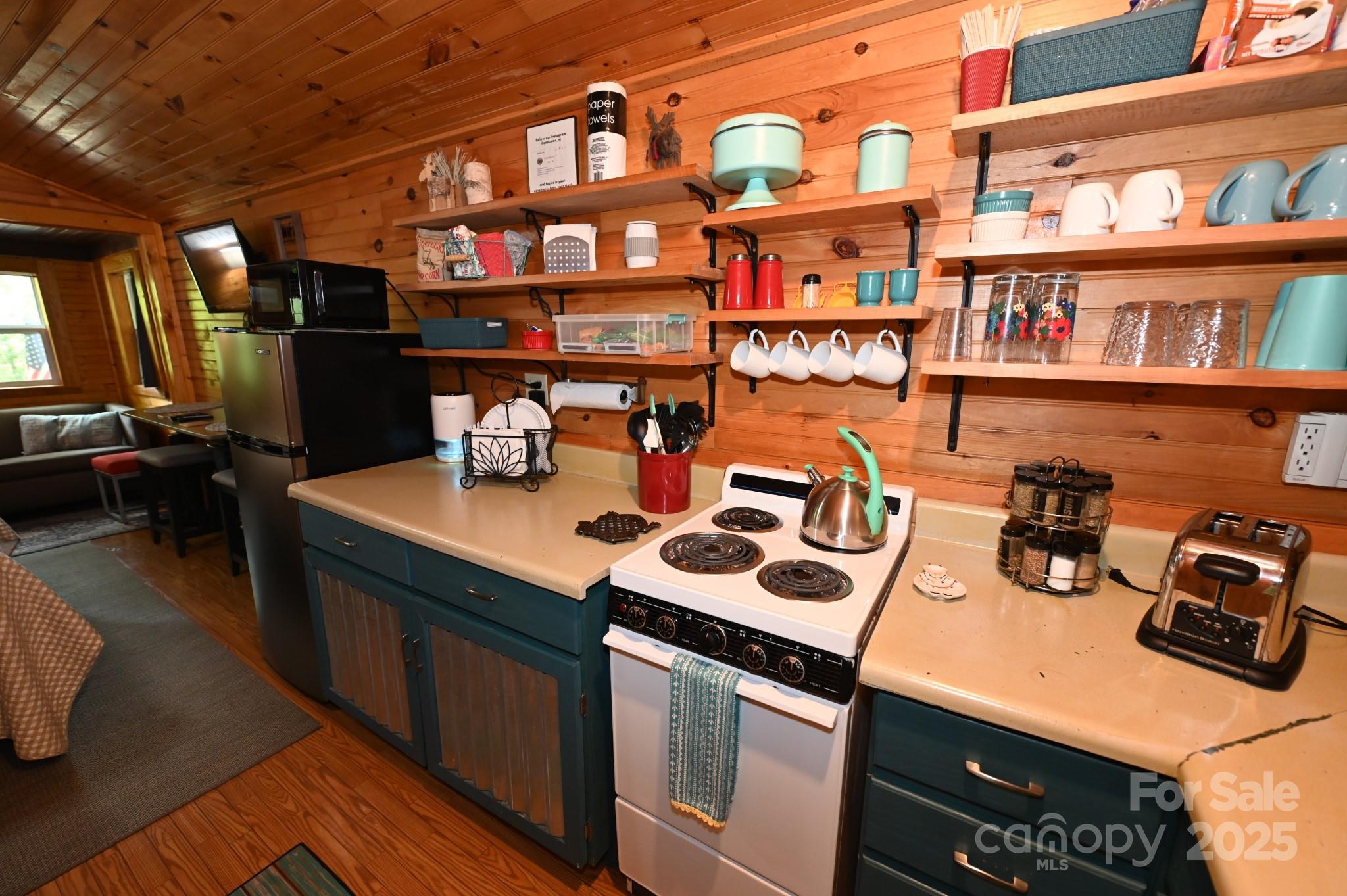 3430 Rose Creek Road Morganton, NC 28655 - Photo 35 of 48 a kitchen with a sink a stove and a bookshelf