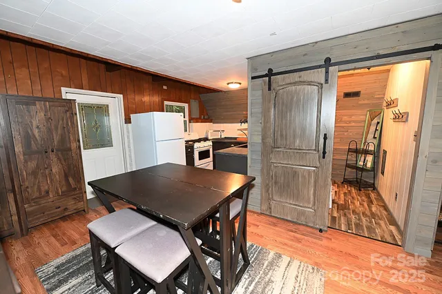 a kitchen with stainless steel appliances granite countertop a refrigerator a stove a sink a dining table and chairs