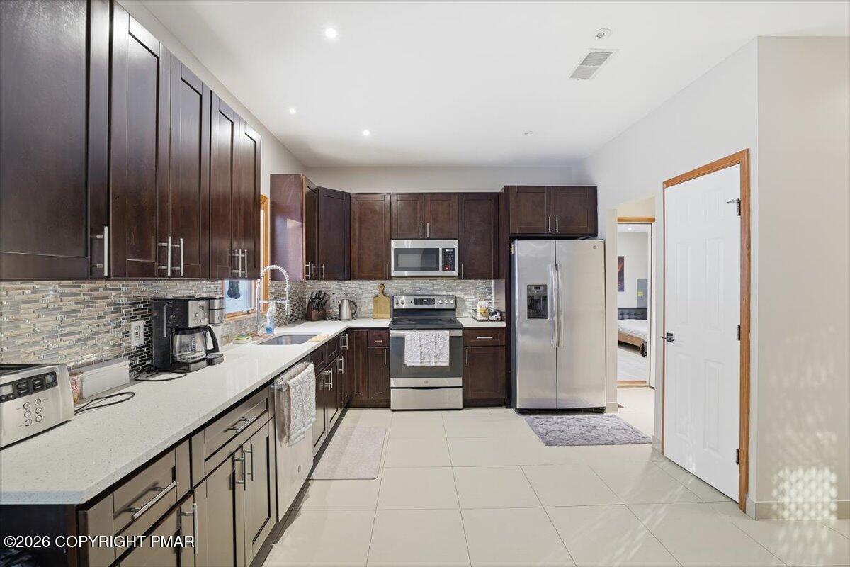 782 Lower Deer Valley Road Tannersville, PA 18372 - Photo 23 of 56 a kitchen with stainless steel appliances granite countertop a refrigerator stove top oven and sink