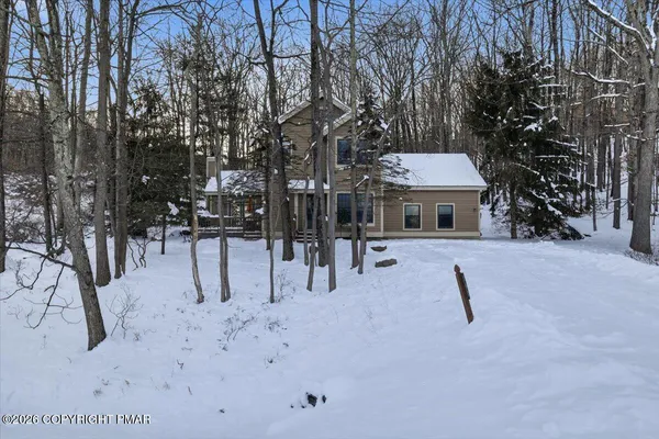 a view of a house with a yard covered in snow
