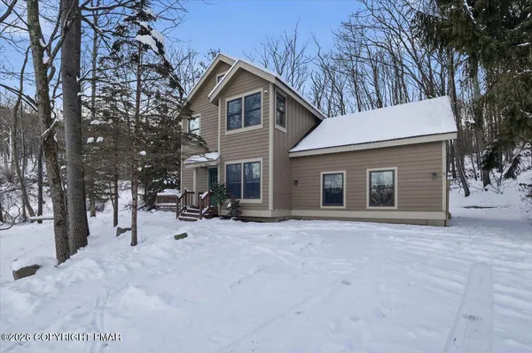 a view of a house with a wooden deck and a backyard