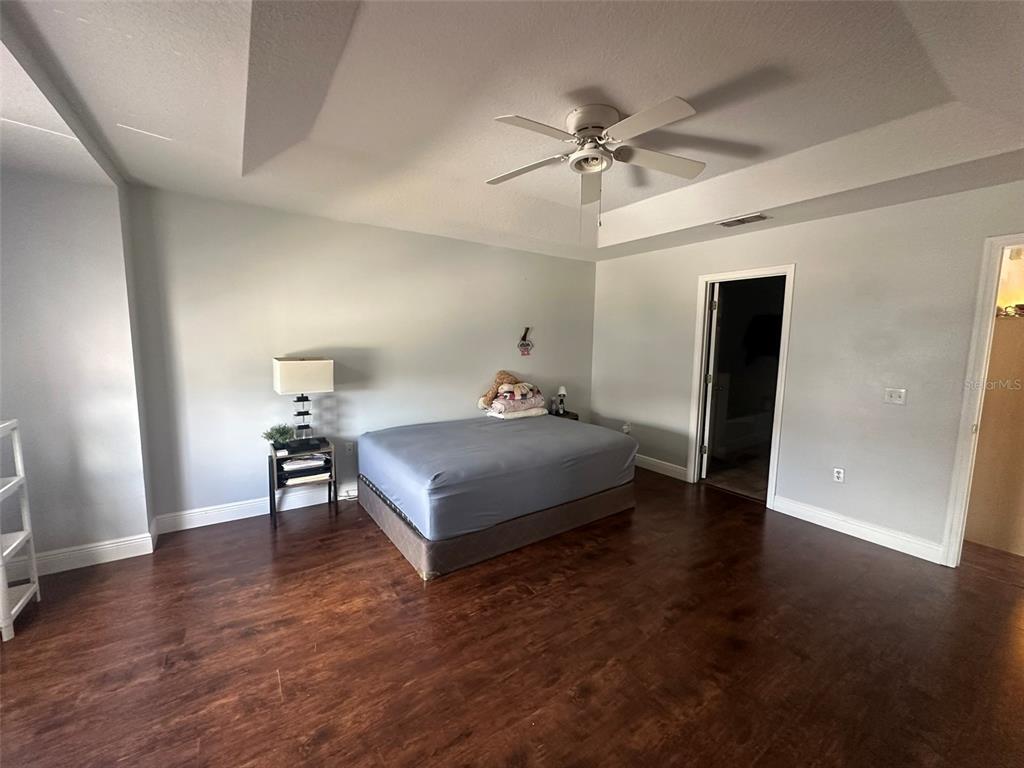 2510 Hassonite Street Kissimmee, FL 34744 - Photo 8 of 22 a spacious bedroom with a bed and wooden floor