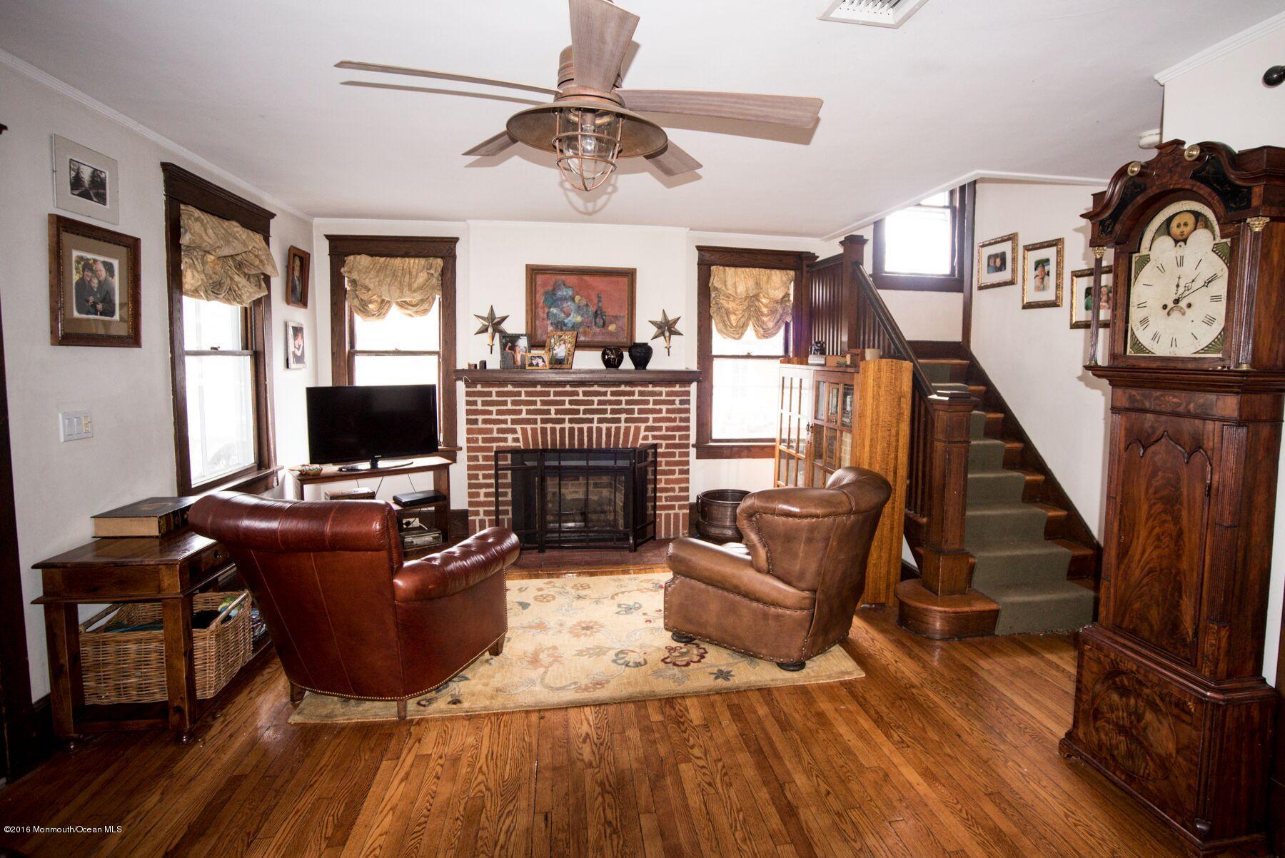 89 Pinckney Road Red Bank, NJ 07701 - Photo 3 of 26 a living room with furniture a flat screen tv and a fireplace