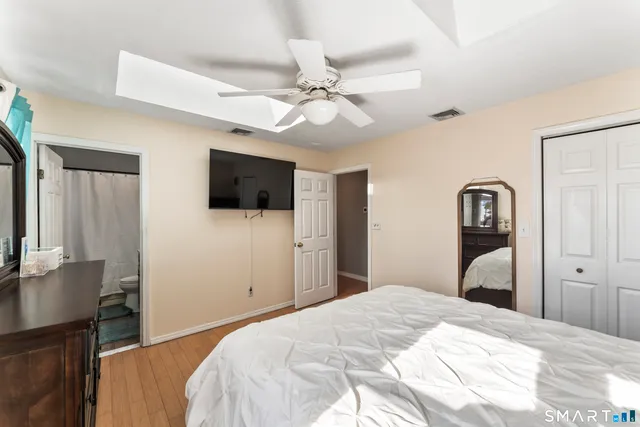 a bathroom with a granite countertop sink toilet and mirror