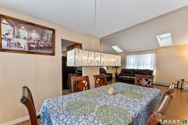 a kitchen with stainless steel appliances granite countertop a refrigerator a sink dishwasher a stove and white cabinets with wooden floor