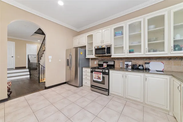 a kitchen with stainless steel appliances granite countertop a refrigerator and a stove top oven