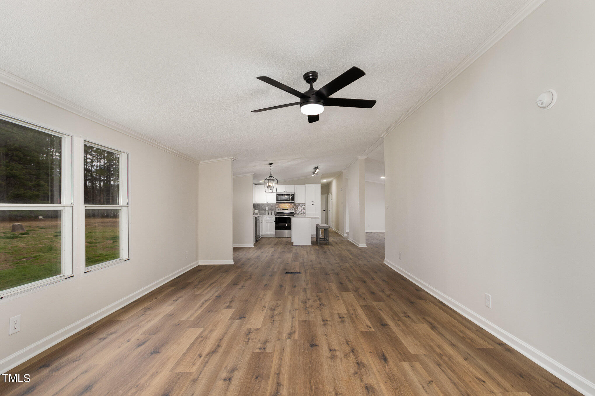 1183 Diamond Hills Road Stem, NC 27581 - Photo 12 of 28 a view of a livingroom with wooden floor and a ceiling fan