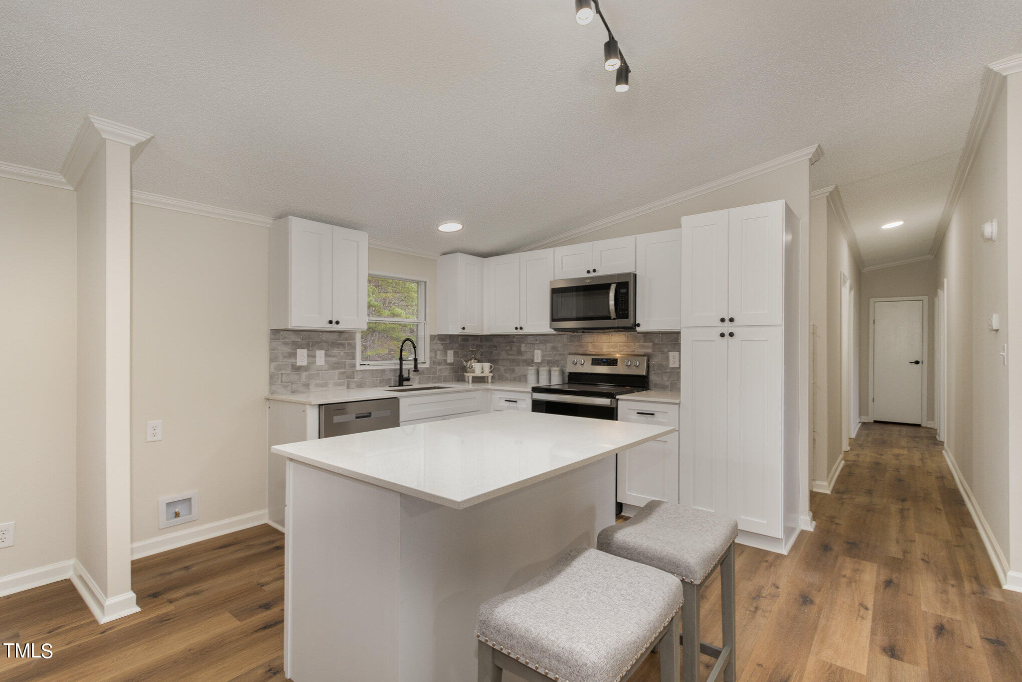 1183 Diamond Hills Road Stem, NC 27581 - Photo 6 of 28 a kitchen with white cabinets and stainless steel appliances