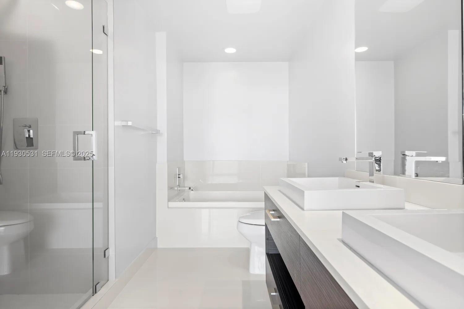 55 Southwest 9th Street, Unit 3806 Miami, FL 33130 - Photo 11 of 24 a bathroom with a sink a toilet and shower