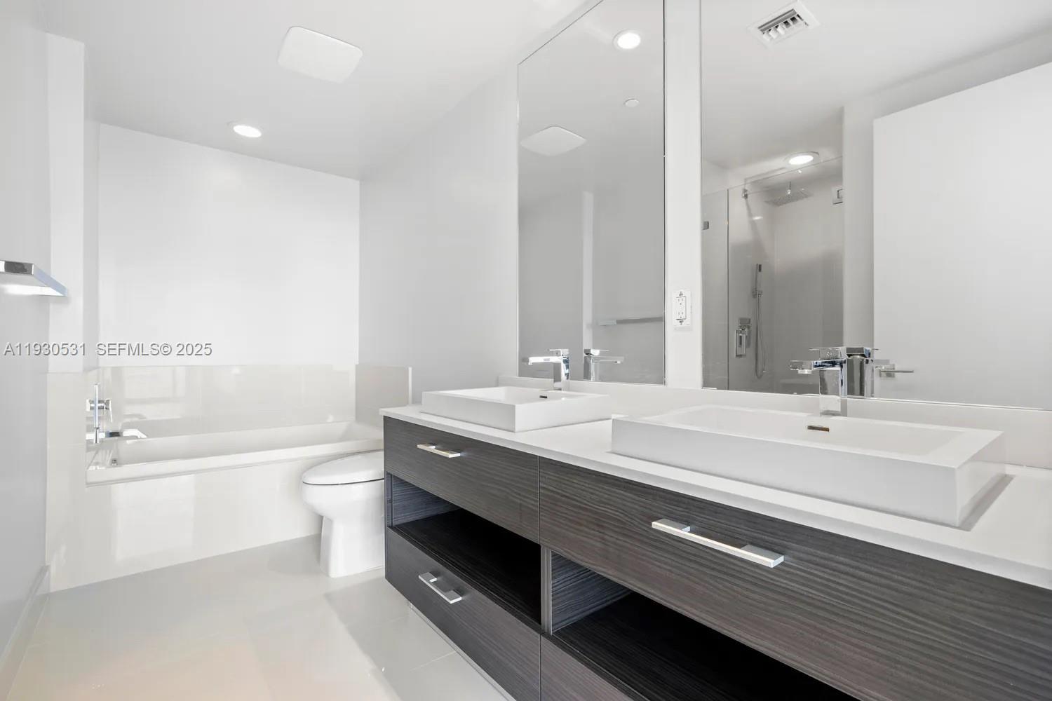 55 Southwest 9th Street, Unit 3806 Miami, FL 33130 - Photo 13 of 24 a bathroom with a double vanity sink a toilet and a bathtub
