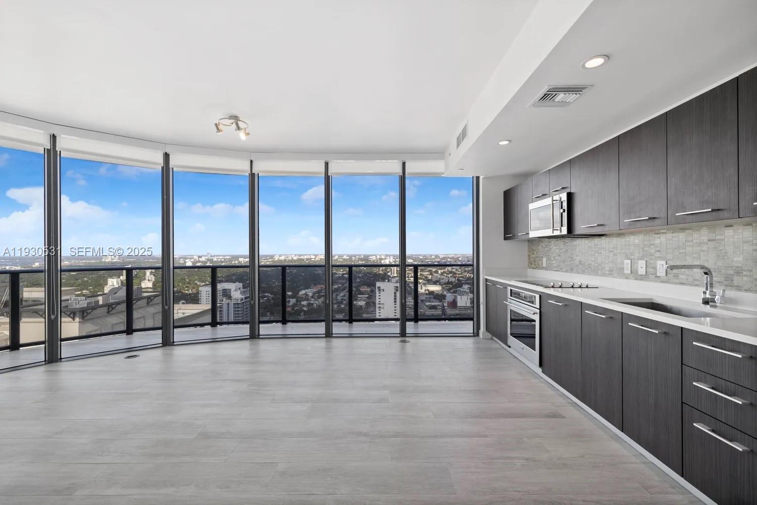 55 Southwest 9th Street, Unit 3806 Miami, FL 33130 - Photo 2 of 24 a kitchen with stainless steel appliances granite countertop a stove and cabinets with wooden floor