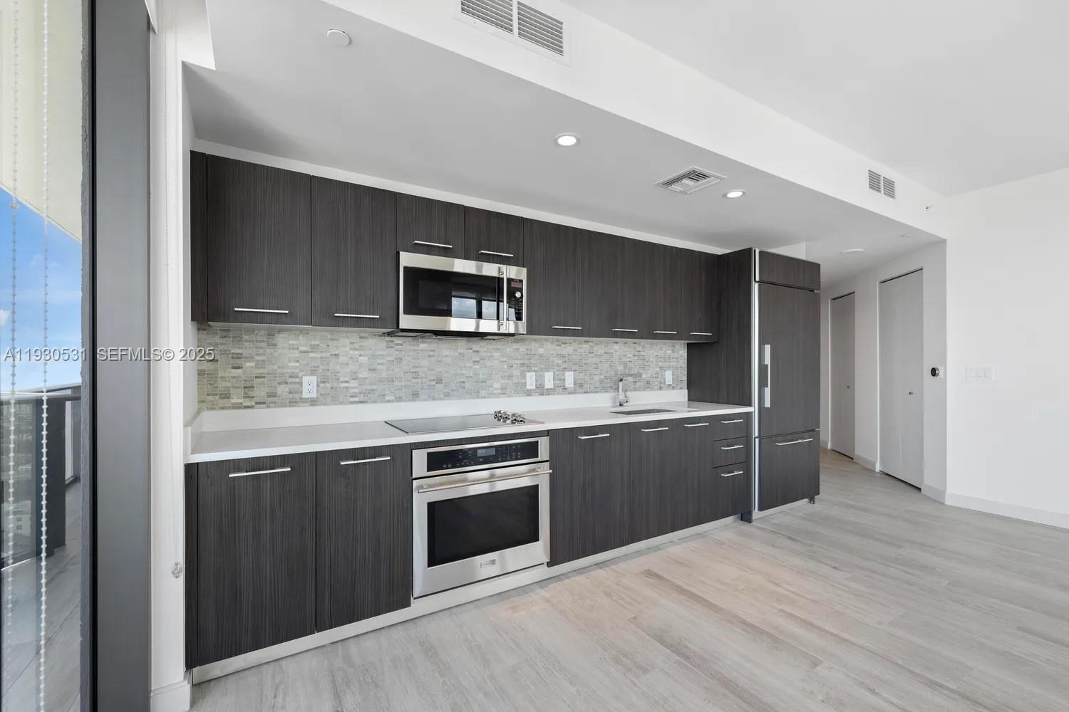 55 Southwest 9th Street, Unit 3806 Miami, FL 33130 - Photo 6 of 24 a kitchen with stainless steel appliances granite countertop a stove and a sink