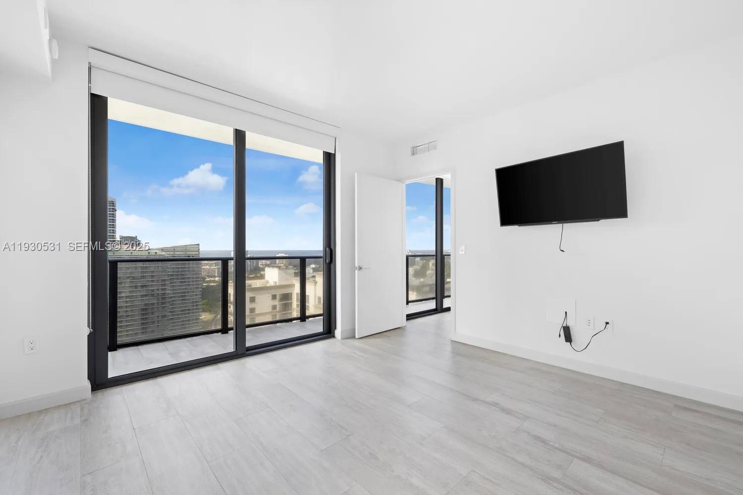 55 Southwest 9th Street, Unit 3806 Miami, FL 33130 - Photo 9 of 24 an empty room with windows and view of a lake