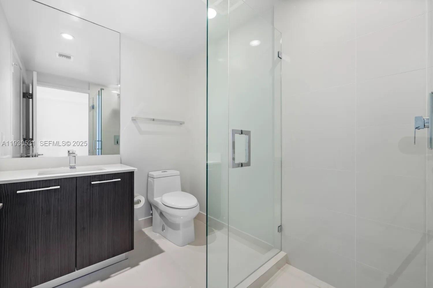 55 Southwest 9th Street, Unit 3806 Miami, FL 33130 - Photo 10 of 24 a bathroom with a sink a toilet and shower