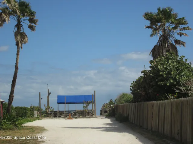 a vase of flowers sitting on a table with potted plants